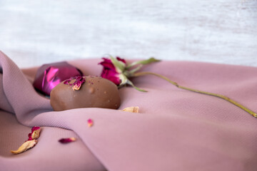 Chocolate pieces with flowers and roses on pink and white background also with mock up space