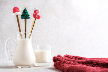 Milk in a glass jug with Christmas-themed straw and Red Coat.