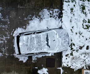 snowy yard with terrace. the parked car is subtly camouflaged in outline. observation of the object by the enemy with the help of the drone operator. cleaning and maintenance of advertising objects