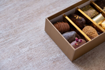 Top-View of Luxury Chocolate Box with Multiple Varieties in Stunning Golden Hues. Elegant Packaging with Copy Space. Perfect for Celebrations, Gifts, and Indulgent Occasions