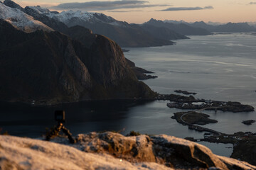 Views from top of Reinebringen mountain hike in Lofoten, Norway.  Snow covered mountains captured on image by a mirrorless camera.  Located far North in the Arctic Circle.  