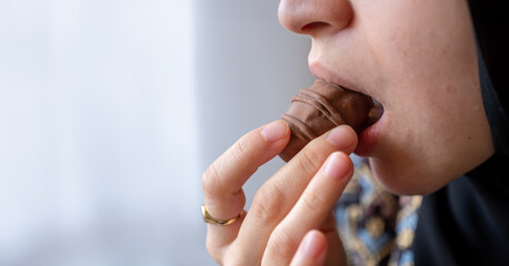 Close-Up Photo of a Woman's Mouth Savoring a Chocolate Delight with Ample Copy Space. Indulgence and Temptation Concept. Ideal for Dessert Enthusiasts and Sweet Treat Advertisements
