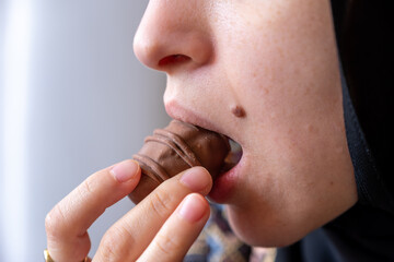 Close-Up Photo of a Woman's Mouth Savoring a Chocolate Delight with Ample Copy Space. Indulgence and Temptation Concept. Ideal for Dessert Enthusiasts and Sweet Treat Advertisements