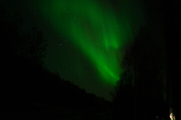 Green Northern Lights Dancing in Arctic skies above Norway.  Beautiful and tranquil Aurora Borealis in the arctic circle in Northern Norway.  Shot on a mirrorless camera in the late fall near Troms