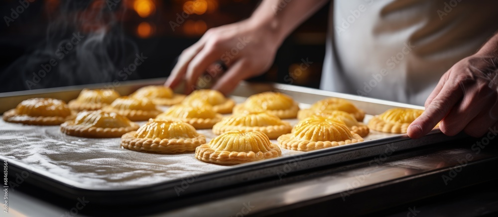 Aufkleber chef s hands fill a small pie raw baked goods rest on a metal baking sheet in a bakery pie and flour