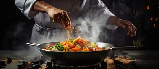 Fototapete Busy chef cooking stir fry in the kitchen copy space image © vxnaghiyev