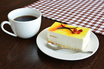 slice of lemon cheesecake with cup of coffee close up   
