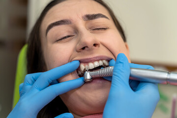 Dentist doctor treats caries in a patient using tooth drill