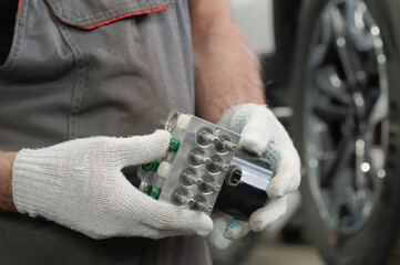 Anti-lock abs system. An abs valve block is in the hands of an auto mechanic. Replacement of the...