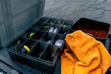 close-up box with fishing lures lines and hooks on the pier on the river bank nature sport fishing
