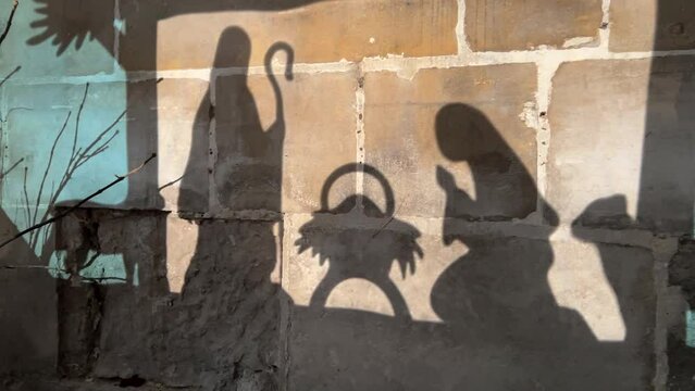 Reflection on the wall of christmas creche with Joseph Mary and Jesus in a crib