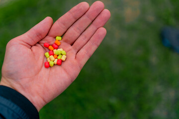 close-up of fisherman's hand holding colorful edible fish bait sport fishing outdoors