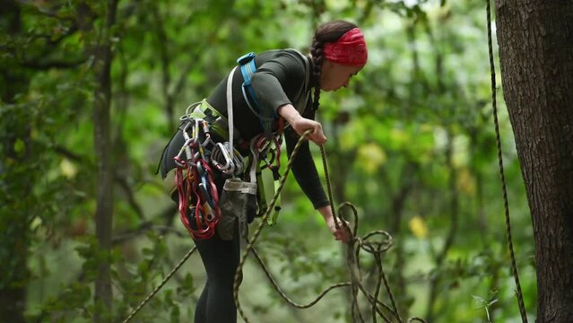 A climber with his equipment in a rocky mountain forest.
