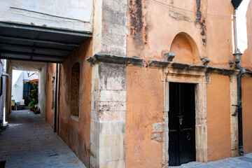Agia Ekaterini Chapel at Chania Old Town, Crete island, Greece. Arched stonewall covers paved alley.