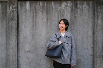 Obraz premium コンクリートの壁に寄りかかる女性のポートレート