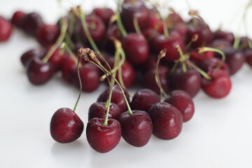 Vibrant, succulent cherries nestled together in a delightful cluster, showcasing rich hues of red against lush green stems