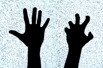 Two hands on a white noise TV screen background, black silhouettes, shapes. Scary creepy hand...