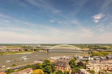 View at the Waal river with cargo riverboats passing the Dutch city of Nijmegen