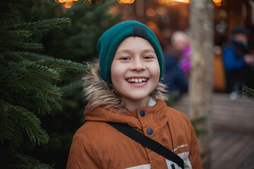 Cute happy 8 year old boy at European Christmas market. Holidays. New Year. Winter vacation.