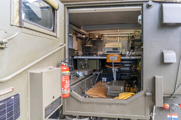 The interior of an old communication vehicle of the Dutch army, equipped with a modern fire extinguisher