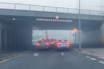 Scenic city road traffic light jam wim many cars at foggy misty rainy haze morning low poor...