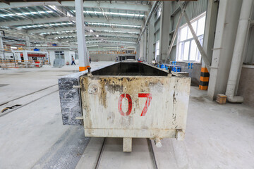 The raw material transport vehicle is on the track in a factory