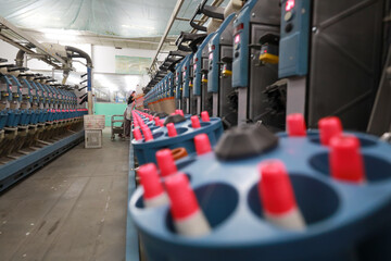 The spinning worker is working nervously on the spinning production line in a spinning factory,...