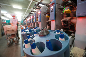 The spinning worker is working nervously on the spinning production line in a spinning factory