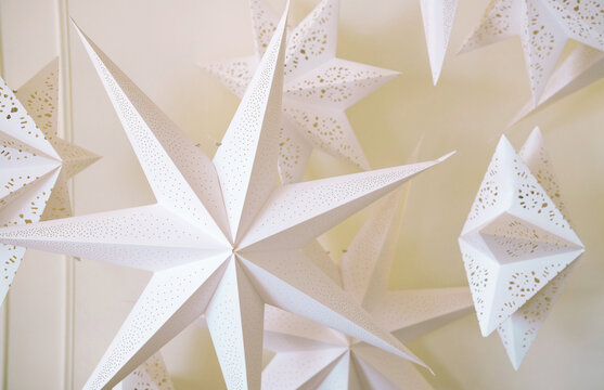 Big paper perforated white stars in front of a white background