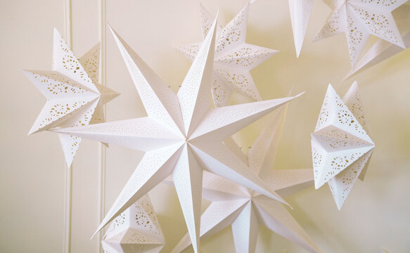 Big paper perforated white stars in front of a white background