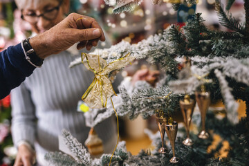 Man decorates the Christmas tree. Preparing for the holidays