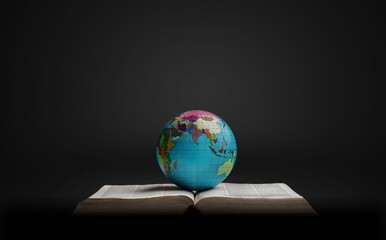 Globe with open Holy Bible for christian idea.