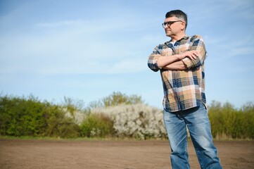 A farmer checks quality of soil before sowing.