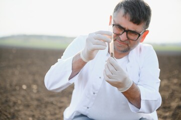 Soil Sampling. Agronomist taking sample with soil probe sampler. Environmental protection, organic...