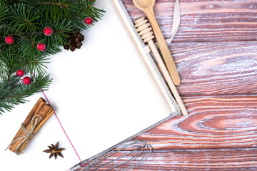 Vintage recipe book and Christmas decor on a wooden table. Holiday baking concept. Flatlay. Top...