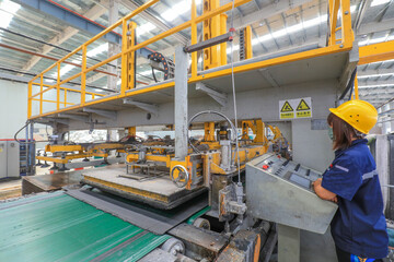 Workers work nervously on the production line of new building materials calcium silicate board,...