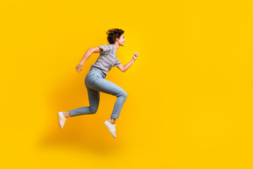 Fototapeta na wymiar Full length profile portrait of excited energetic person jump rush empty space isolated on yellow color background