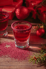 Two glasses of red liqueur on wooden background. Winter holidays, Christmas or new year party celebration concept