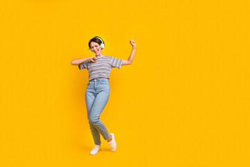 Fototapeta na wymiar Full body portrait of cheerful lovely meloman lady enjoy favorite song dancing empty space isolated on yellow color background