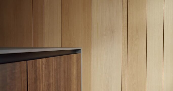 Wooden furniture and wall at home. Pan left view of lumber cabinet located against timber wall in sunlit room, Wooden panels in kitchen room.