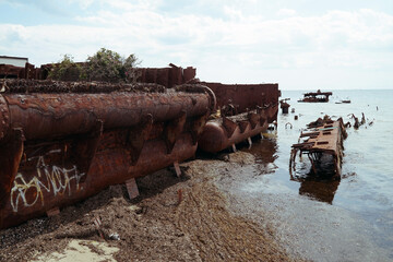 The rusty hull of an old ship on the shore of the Baltic Sea.