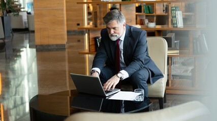 Businessman looking busy working on laptop. Thoughtful business professional reading emails on...
