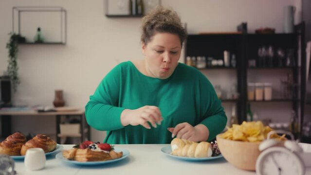 Hungry overweight woman eating salty chips, sweet cake, unhealthy food addiction