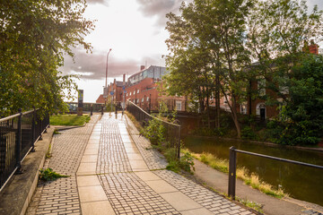 Empty cobbled path for pedestrians and cyclists along a canal ar sunset in summer