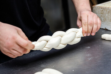 Making braided bread in a bakery. Traditional Shabbat challah