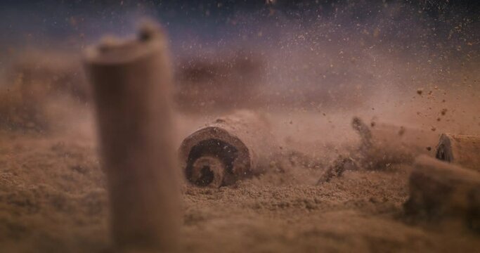 Super slow motion macro of dry cinnamon sticks falling on aromatic cannella powder scattered on rustic wooden table on restaurant kitchen.