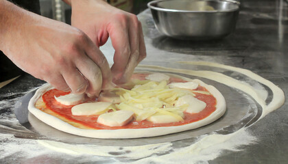 Hands making a pizza