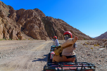 Young woman driving quad bike during safari trip in Sinai desert not far from the Sharm El Sheikh...