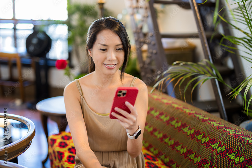 Poster Woman use mobile phone and sit inside coaffee shop