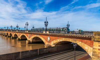 A tram passing over the stone bridge over the Garonne in Bordeaux, in Gironde, Nouvelle-Aquitaine, France